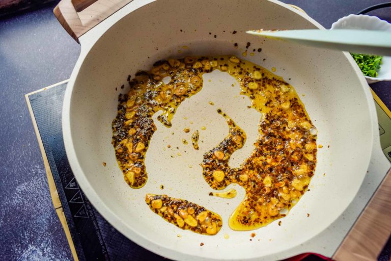 tossing garlic and red pepper flakes