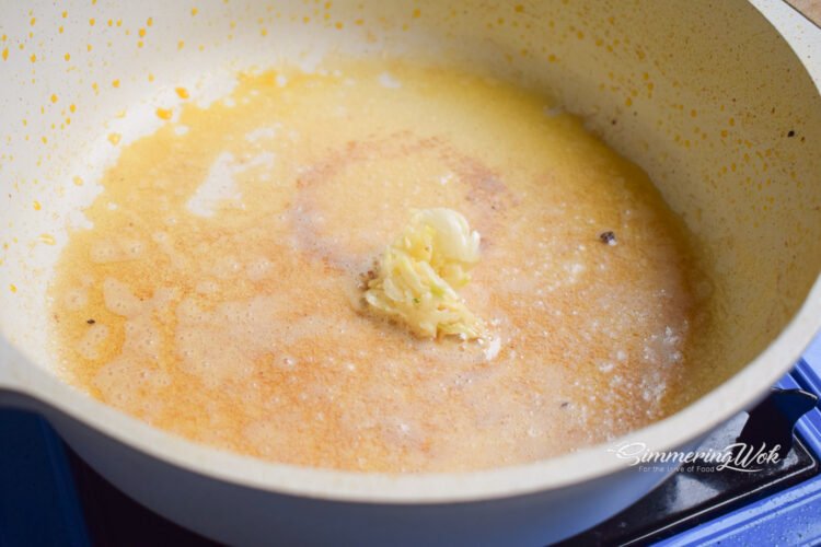 Butter melting in a pan with minced garlic sizzling creating an aromatic base for the sauce