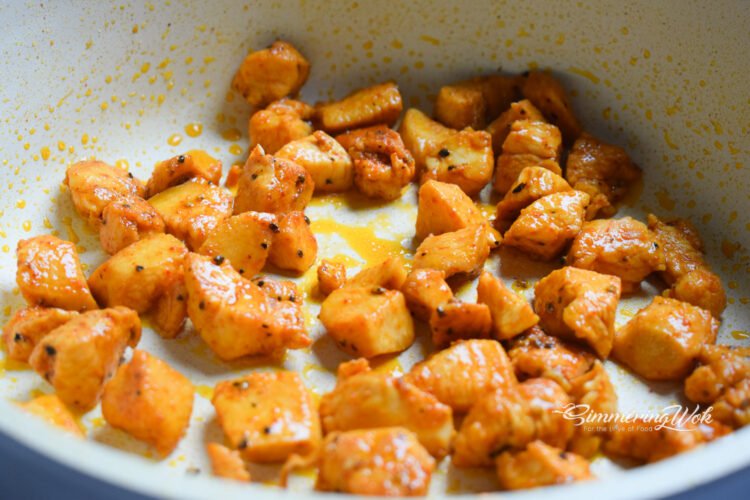 Chicken pieces cooking golden brown in a pan with beautiful caramelization