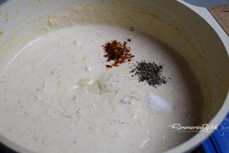 Chilli flakes and black pepper sprinkled into the creamy parmesan sauce adding color and heat