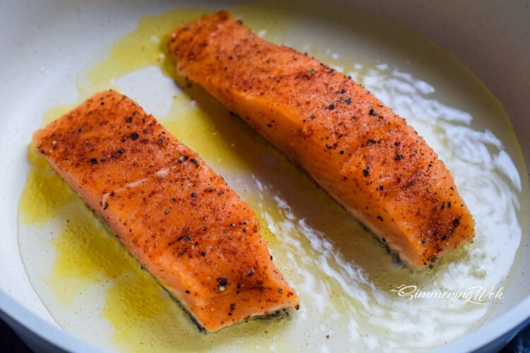 Pan seared salmon with golden crust after flipping, showing perfectly seared top